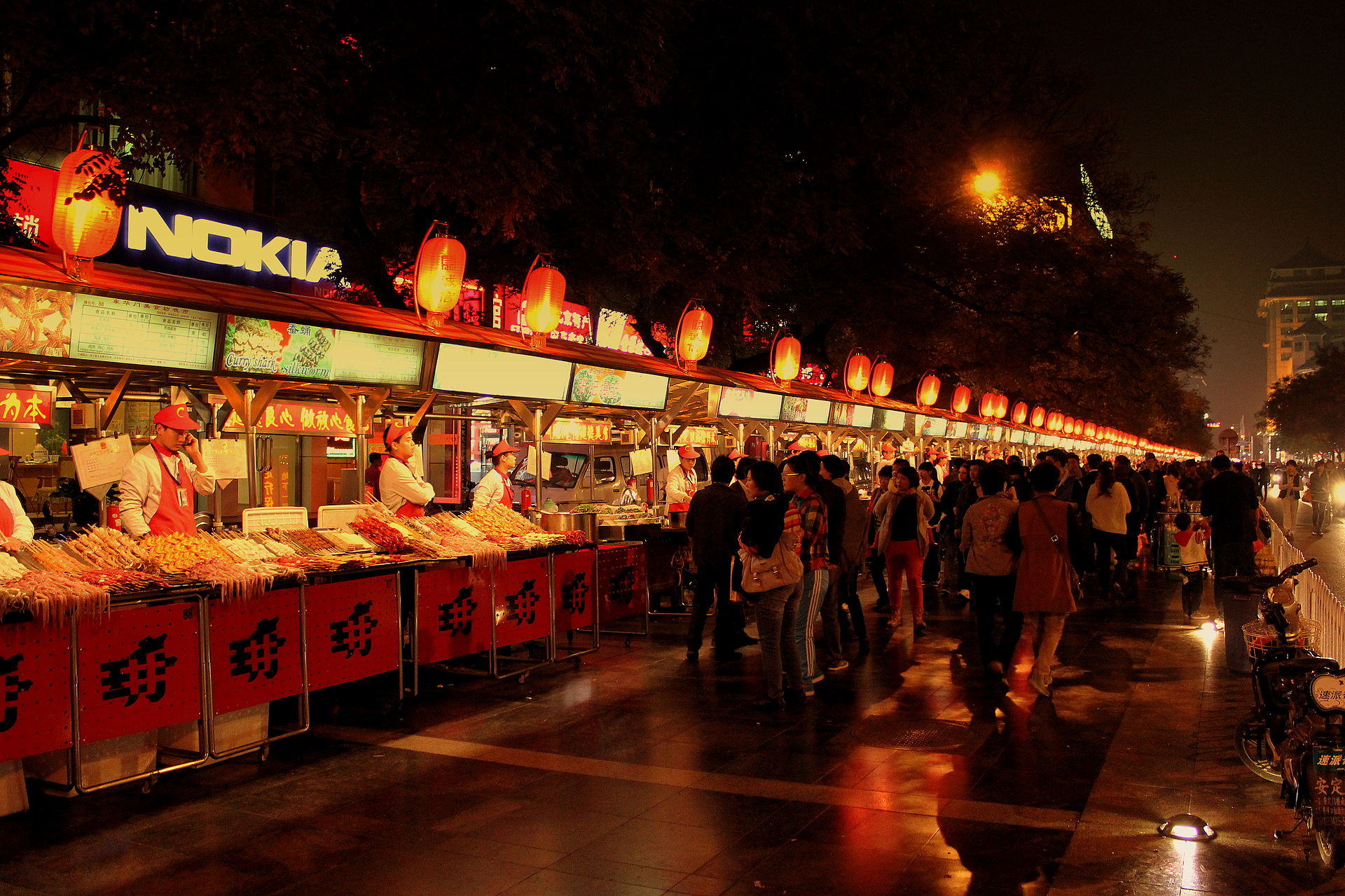 A busy night market glowing with signs