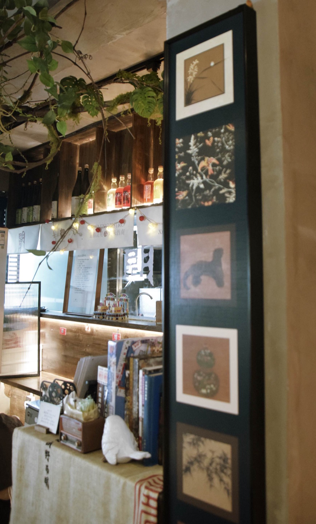The bar — house-infused bottles, a noren curtain, books and a bird sculpture